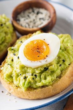 an egg is sitting on top of avocado toast