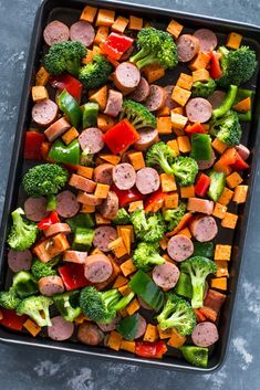 a pan filled with sausage, broccoli and peppers