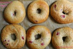 four bagels with holes in them sitting on wax paper