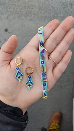 a person holding two different types of beaded bracelets and rings in their hand