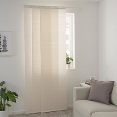 a living room with a white couch and window