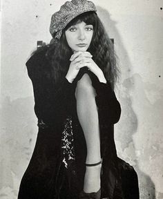 an old black and white photo of a woman wearing a hat