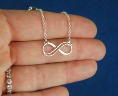 Sterling silver double infinity necklace, infinity knot, infinity symbol, bridal jewelry, sterling silver necklace, eternity necklace A double wire infinity link is attached to a sterling silver chain that can be any length up to 22 inches in length and is secured with a sterling silver lobster claw clasp. You can choose between the small, medium, and large infinity links. The small infinity measures 0.55 x 0.26 inches (14 x 6.5mm). The medium infinity measures 0.79 x 0.37 inches (20 x 9.5mm). T Sterling Silver Infinity Necklace With Adjustable Chain, Silver Infinity Necklace In Dainty Style, Silver Infinity Dainty Necklace, Silver Infinity Jewelry With Adjustable Chain, Silver Infinity Necklace With Delicate Chain, Silver Dainty Infinity Necklace, Silver Infinity Jewelry, Dainty Silver Infinity Necklace, Dainty Infinity Silver Jewelry