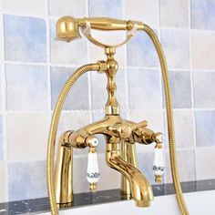 a gold faucet sitting on top of a bath tub