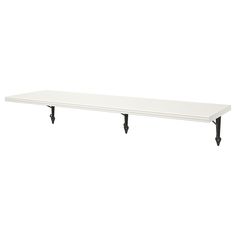 a white shelf with two black legs on it's sides and one is empty