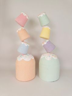 three different colored cakes stacked on top of each other in front of a white background