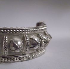 "Up for sale is this Yemeni inspired collectible, very fine, handmade, filigree sterling silver bangle bracelet. This is 3/4\" wide and 6 1/2 \" inner diameter, weighing 20.3 grams. It will fit up to 7\" wrist. It features 16 small domes in the center with wire work border, pull clasp with safety latch. It is marked 830S which is from Denmark. Condition In good vintage condition. Shows some dents dings, metal discoloration, aging patina, darkening seen which comes with use and age. The clasp is Traditional Jewelry With Historical Design For Collectors, Victorian Cuff Bracelet With Intricate Design For Ceremonial, Victorian Cuff Bracelet With Intricate Design For Ceremonial Occasions, Victorian Style Ceremonial Cuff Bracelet With Intricate Design, Adjustable Antique Sterling Silver Bracelet, Victorian Jewelry With Decorative Band For Ceremonial Occasions, Victorian Ceremonial Jewelry With Decorative Band, Antique Adjustable Sterling Silver Bangle Bracelet, Adjustable Antique Sterling Silver Bangle