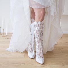 the bride is wearing white boots with lace on them and she has her legs tied up