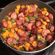 a pan filled with meat and vegetables on top of a stove