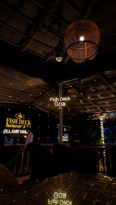 the fish deck is lit up at night with neon signs and lights hanging from the ceiling