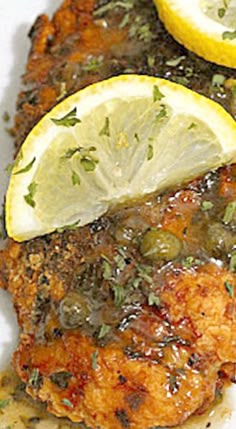 grilled chicken with lemon and capers on a white plate