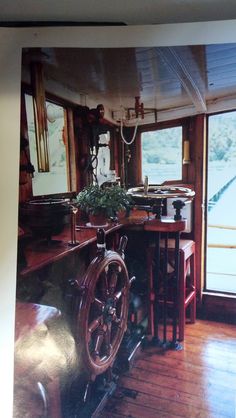 an old photo of a boat's steering wheel in the living room with wood flooring