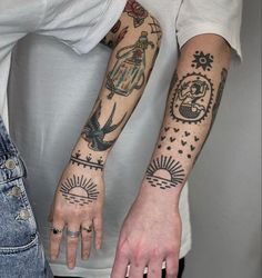 two people with tattoos on their arms and hands, both holding each other's hand