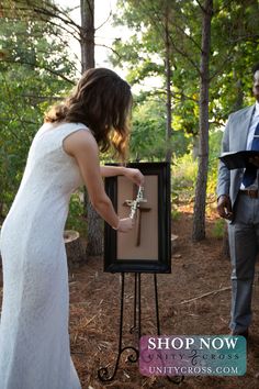 a man and woman standing in the woods holding keys to a box with a keychain on it