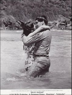 two people are hugging in the water while another person is holding their head up to his chest