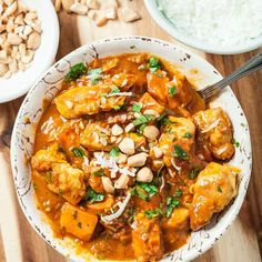 a white bowl filled with food on top of a wooden table next to other bowls