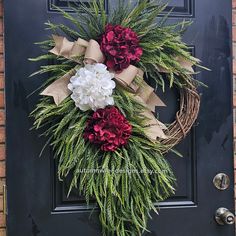 a wreath with flowers is hanging on the front door to decorate it for someone's special occasion