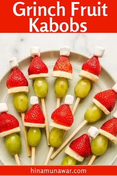 fruit kabobs on a white plate with strawberries and green grapes in santa hats