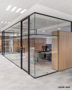 an office cubicle with glass walls and desks