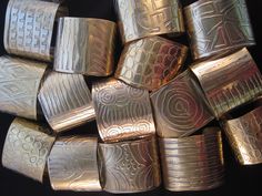 a pile of silver colored metal objects sitting on top of a black table next to each other