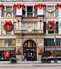 an ornate building decorated for christmas with wreaths and decorations on the front entrance door