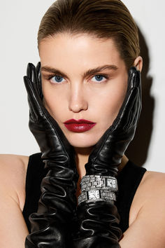 a woman wearing black gloves and red lipstick