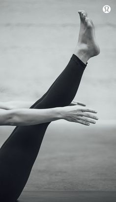 a black and white photo of a woman stretching her arms out with the words yoga written below it