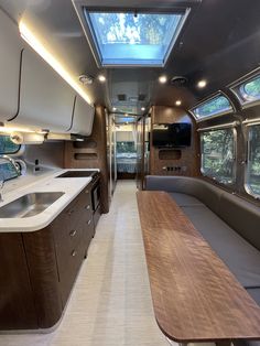 the inside of a camper with a kitchen and dining area