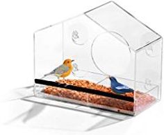 two birds sitting on top of a bird feeder in a clear plastic box with holes