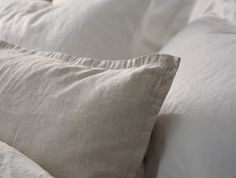 two white pillows sitting on top of a bed