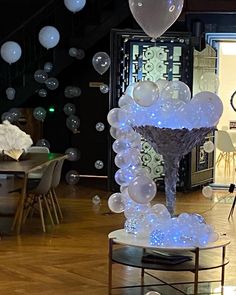 balloons are floating in the air on display at a wedding reception, with an elaborate table and chairs