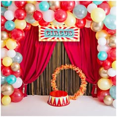 a circus themed birthday party with balloons and streamers around the stage, including a carnival sign