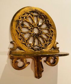 a wooden shelf with a decorative object on it's back end, mounted to the wall