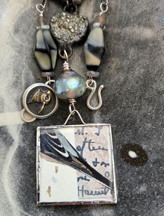 a close up of a necklace on a table with beads and other items around it