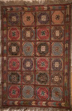 an old rug with many different colors and designs on the carpet, including fringes