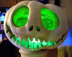 a close up of a fake pumpkin with green lights on it's eyes and mouth