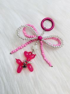 a pair of pink and white beaded hair clips with bows on them sitting on a fur surface