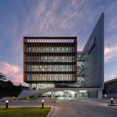 an office building lit up at night with the sky in the background and lights on