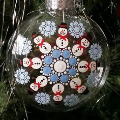 a glass ornament with snowmen on it