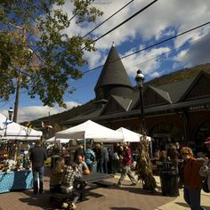 many people are walking around an outdoor market