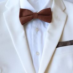 Color:  Brown Material:  Cotton                                                                                                                                                       Adult Pre-Tied Bow Tie:  approx. 4.75 inches wide and 2.5 inches height.  Neck strap is adjustable from 11.5 inches to 20 inches with metal hook for secure and comfortable wear. Child Pre-Tied Bow Tie: approx. 4 inch width and 2 inch length Neck size 11 inches - 19 inches Plastic clasp for each wear and removal. Classic Bow Tie For Groom, White Pocket Square For Black Tie Events, Brown Ties For Business And Father's Day, Dapper White Suit And Standard Tie Accessories, Brown Business Ties For Father's Day, Dapper Bow Tie For Formal Father's Day, Adjustable Bow Tie For Business, Classic Groom Ties, Classic Adjustable Tie For Groom