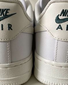 the nike air force sneakers are white and green with black lettering on them, as well as