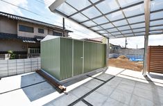 an outdoor area with a metal structure and wooden slats on the ground, next to a building