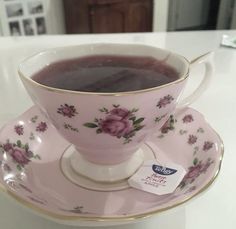 a pink tea cup and saucer sitting on a white counter top with a price tag