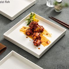 three square plates with food on them and chopsticks next to each other,