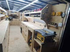 a room filled with lots of work tools and wooden shelves covered in plywood planks