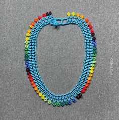 This beautiful beaded necklace is hand-woven by the women of the Embera Chami Indigenous Tribe of Colombia Handwoven Beaded Bracelets With Round Beads, Fair Trade Unique Beaded Necklaces, Blue Round Beads Jewelry Fair Trade, Blue Fair Trade Beaded Necklaces For Festivals, Bohemian Fair Trade Beads, Blue Fair Trade Jewelry With Round Beads, Hand-strung Beaded Necklaces For Festivals, Bohemian Choker With Round Beads And Bead Caps, Handwoven Beaded Necklace For Festival