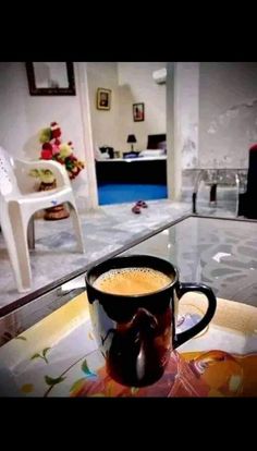 a cup of coffee sitting on top of a glass table