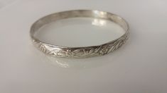 "Flower and leaf design etched into a thick sterling bangle, makes it perfect for stacking.  Stamped Mexico .925 Width: 1/4\" Opening: 2 5/8\" Weight: 16.9g" Stamped Sterling Silver Bangle For Wedding, Sterling Silver Stamped Bangle For Wedding, Elegant Stamped Sterling Silver Bangle, Etched Sterling Silver Bracelet For Wedding, Elegant Sterling Silver Stamped Bangle, Wedding Sterling Silver Stamped Bangle, Vintage Etched Sterling Silver Bangle, Leaf Design, Etching