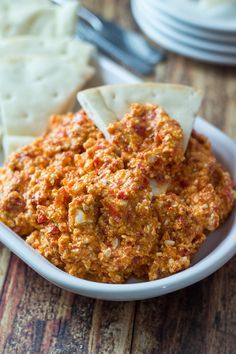 a white bowl filled with cheese and crackers